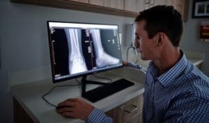 A doctor examining an x-ray image displayed on computer screen