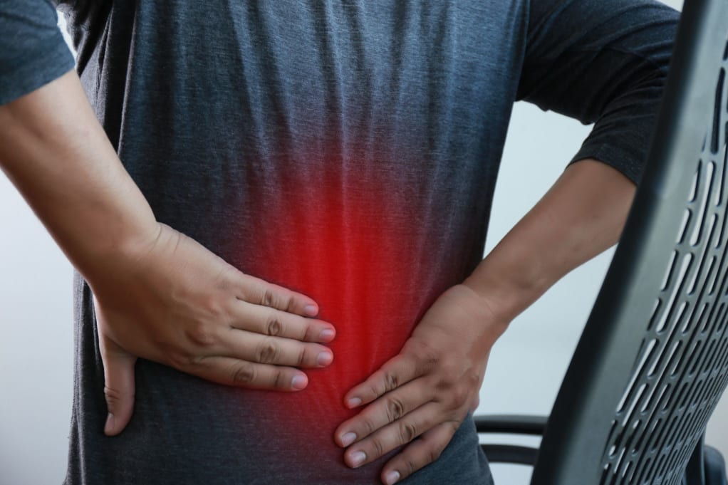 A person experiencing lower back pain likely from a herniated disc