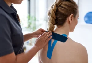 A physical therapist applying kinesio tape on a patient