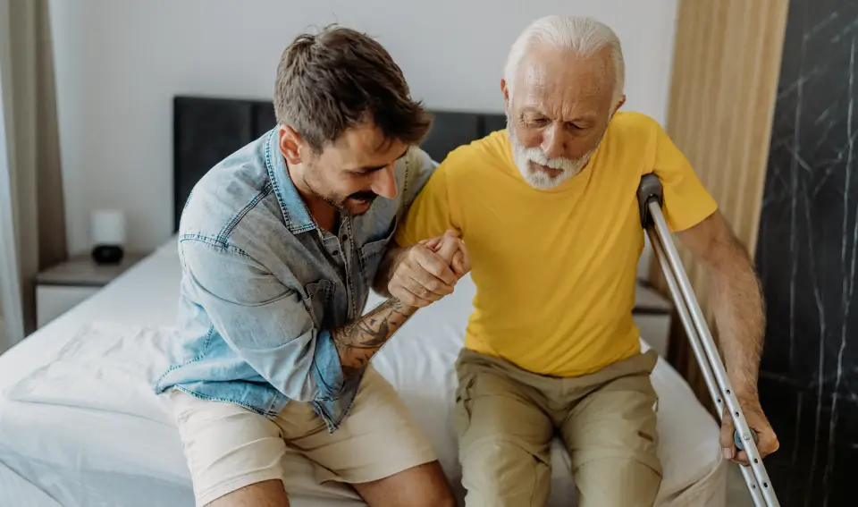 A patient getting helped up after a hip replacement surgery in Central Indiana