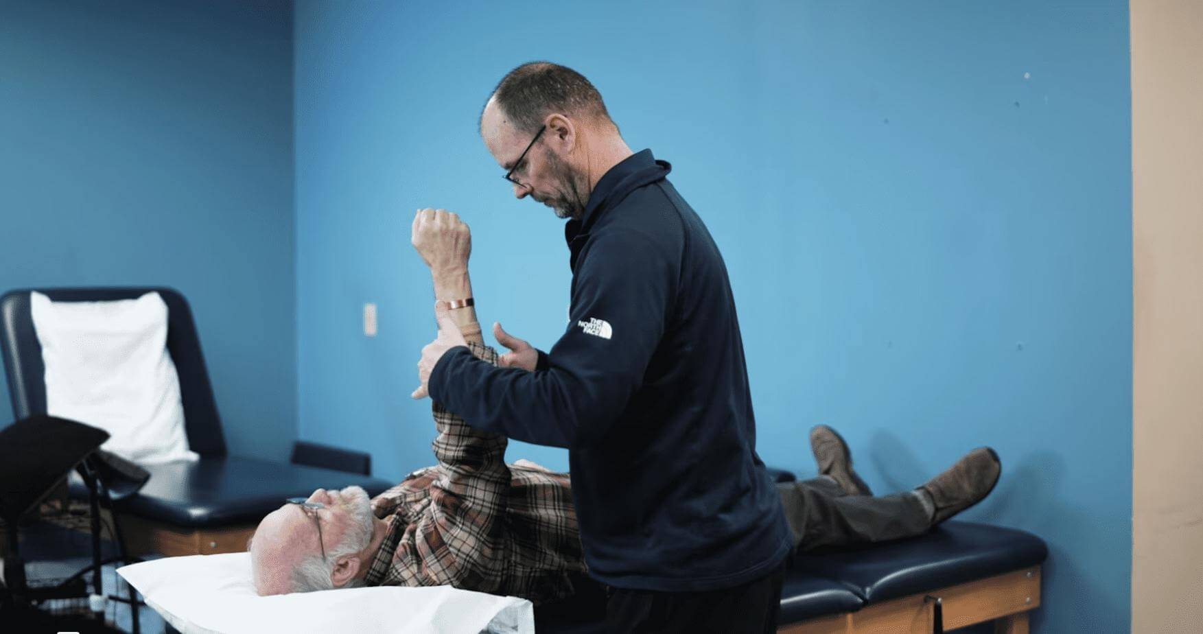 A physical therapist treats a patient with shoulder pain treatments in Greenwood, IN