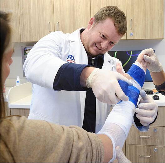 Dr. Matthew Negaard wrapping an arm with tape