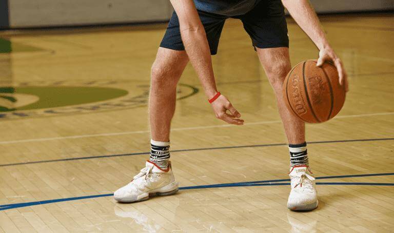 A Man Holds a Basketball in a Gymnasium in Greenwood, IN