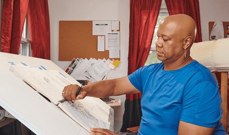 A man at a desk sketches, focusing on Orthopedic Treatments for Neck Pain at Forte Sports Medicine