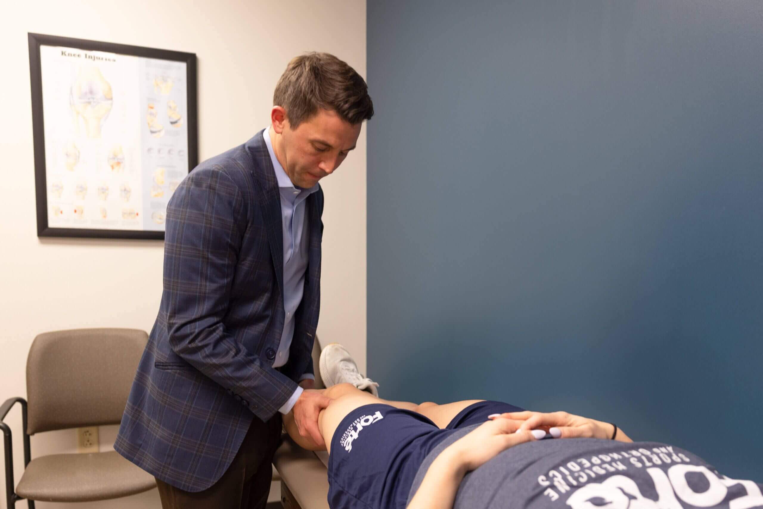 Doctor examines man at Forte Sports Medicine, focusing on ACL injury care and prevention