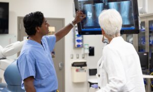 Doctor discusses knee arthroplasty with a patient in a hospital room at Forte Sports Medicine