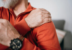 man trying to ease frozen shoulder pain