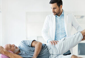 senior man getting physical therapy for hip pain