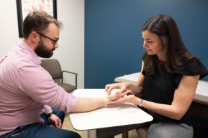 Two people seated at a table discussing tennis elbow treatment at Forte Sports Medicine