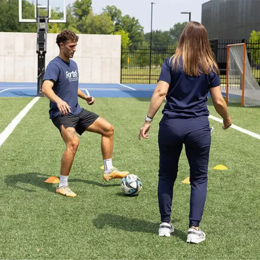 Forte Sports Medicine sports medicine provider playing football on turf in Carmel, IN